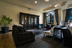 Un salón espacioso con un mueble grande de madera oscura, un sillón estampado con diseño de cebra y una mesa de centro moderna.