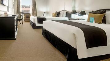 A hotel room with two beds, a desk, and a chair.