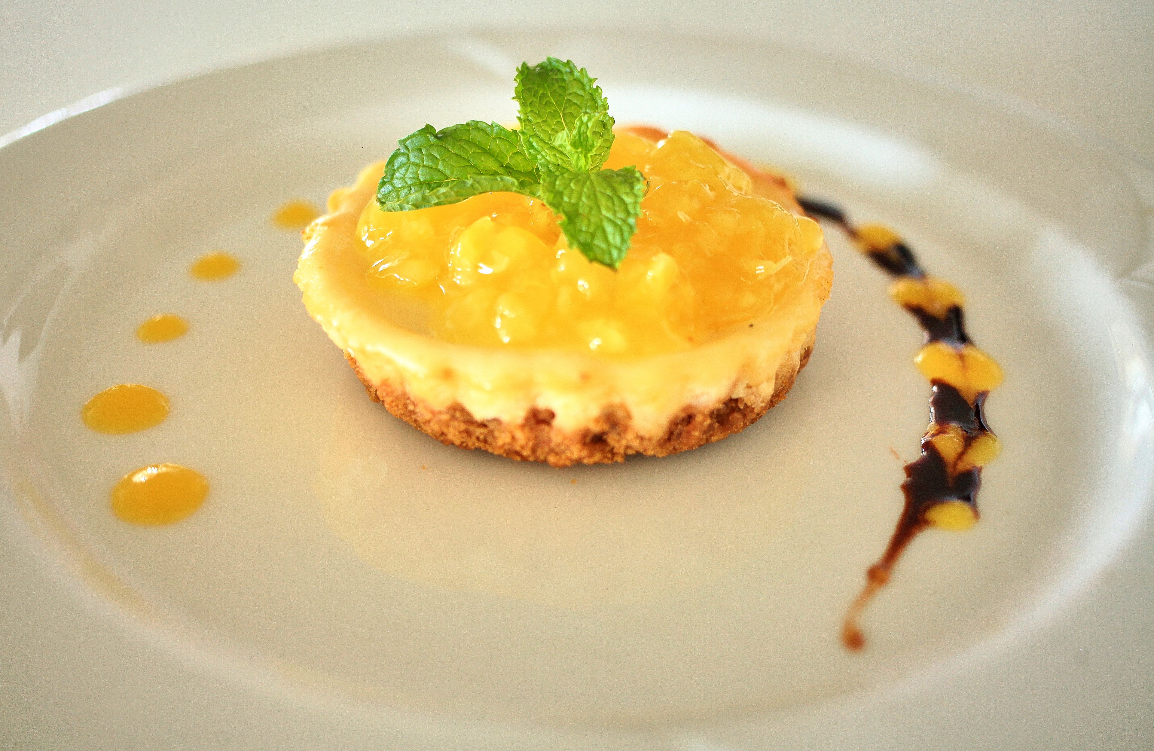 En dessert på en vit tallrik, garnerad med ett myntablad.