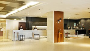 A modern hotel reception area with a marble counter, wooden accents, and a clean, well-lit interior. - Sapporo Tokyu REI Hotel (Sapporo)