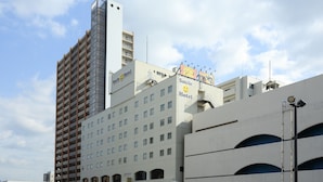 Un hôtel à plusieurs étages doté d’une architecture moderne, avec des balcons et une enseigne bien visible indiquant « Smile Hotel ».