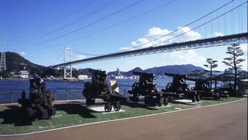 A park with cannons and a bridge in the background.