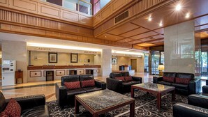 A spacious lobby with leather sofas, a reception desk, and a bell desk. - International Garden Hotel Narita (Narita)
