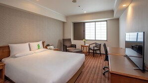 A hotel room with a large bed, a desk, a chair, a TV, and a window. - International Garden Hotel Narita (Narita)