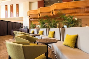 A lobby with seating areas, a reception desk, and a staircase.