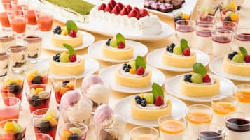 Diversos postres como pasteles, tartas y parfait de frutas, presentados en platos y vasos.
