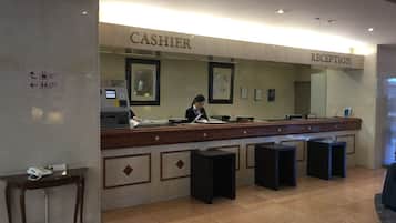 A reception desk with a cashier and a reception area. There is an ATM machine to the left of the cashier.