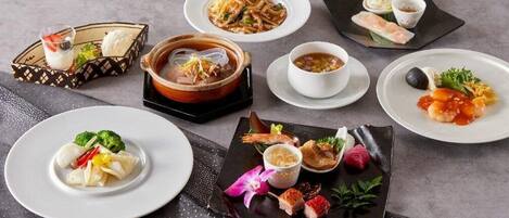 A variety of dishes including dumplings, noodles, and seafood, arranged on a table.