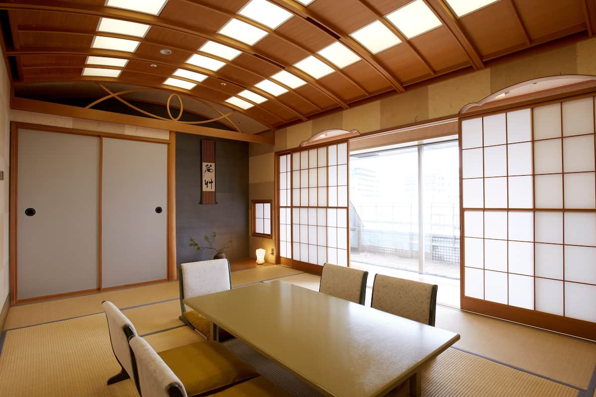 Ein traditioneller japanischer Raum mit Tatami-Böden, einem niedrigen Tisch und Shoji-Schiebetüren.