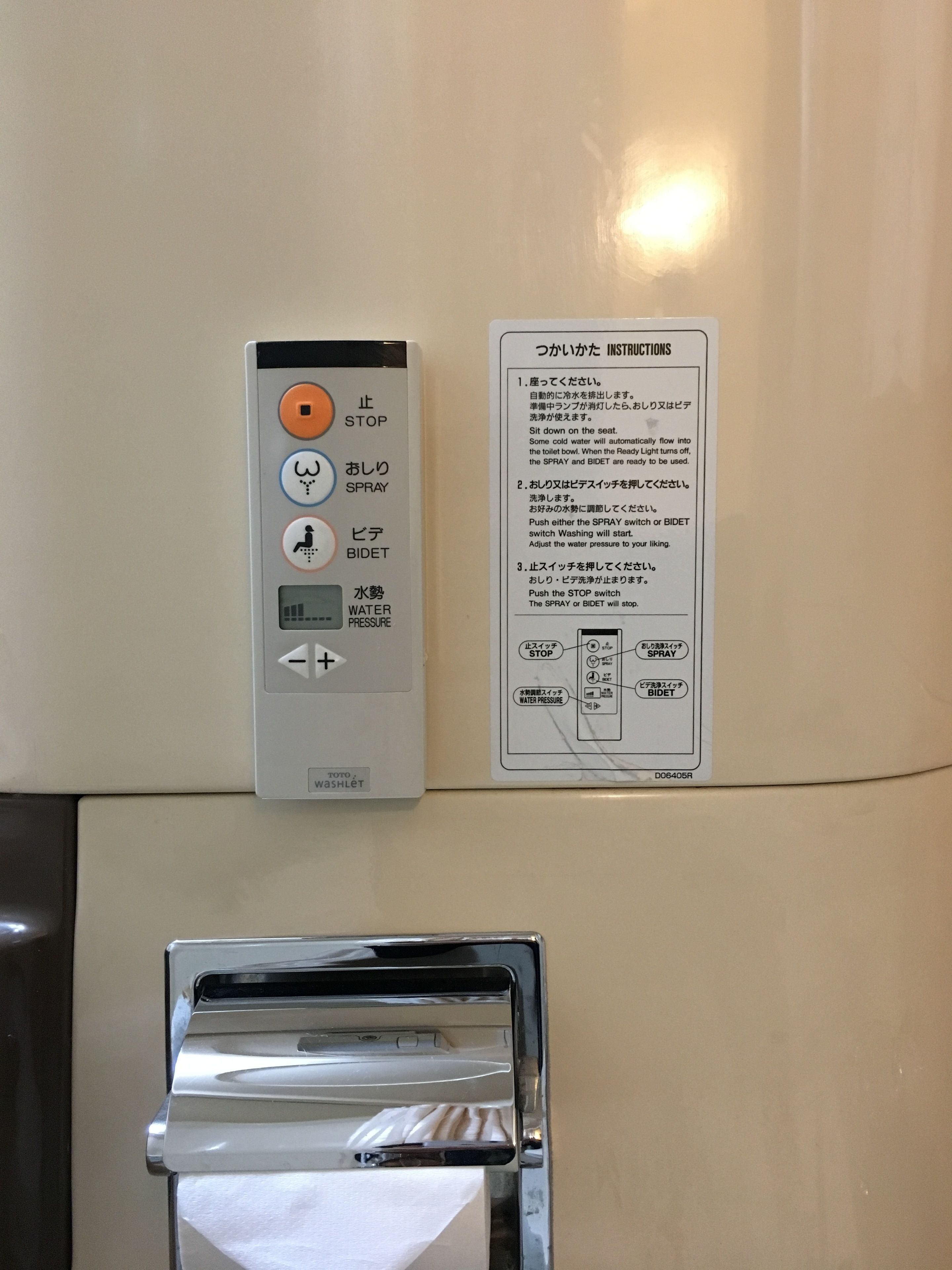 Ein Bedienfeld mit Stopp-, Spray- und Bidet-Knöpfen sowie einem Dial zur Einstellung des Wasserdrucks. Anweisungen sind auf Japanisch angegeben.