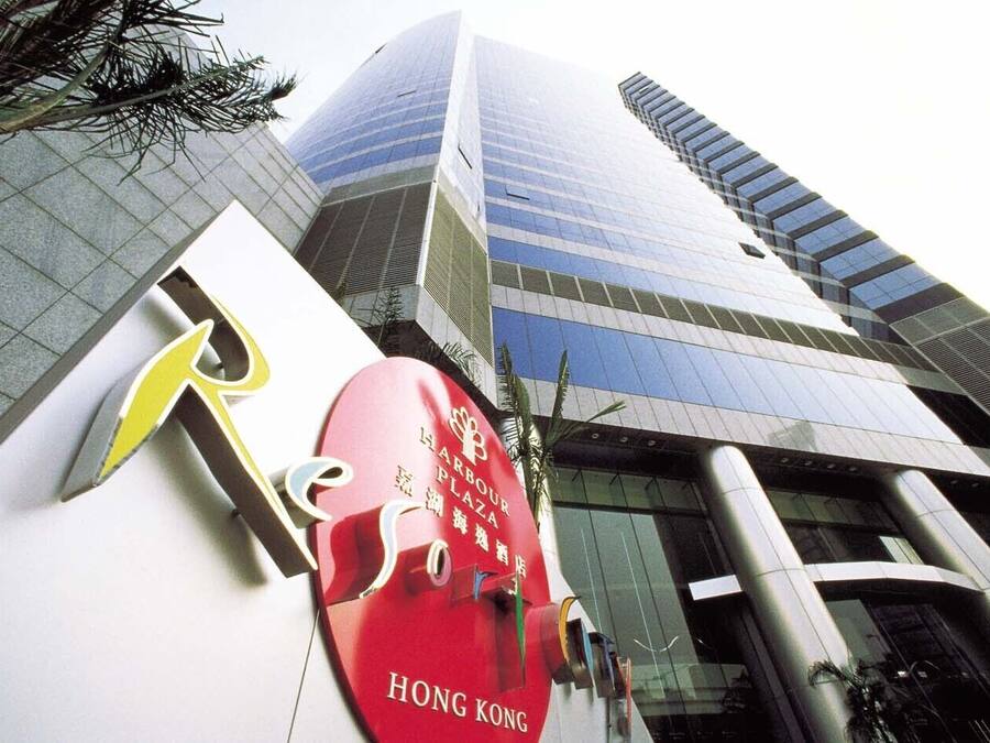 A modern building with a prominent red sign indicating a hotel named 'Harbour Plaza' in Hong Kong.