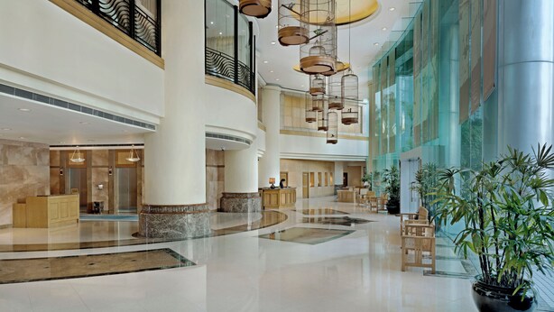 Un hall d’entrée spacieux, doté d’un haut plafond, de grandes fenêtres et d’un espace salon central.