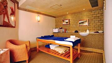 A room with a bed, a chair, a sink, and a mirror.