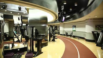 A gym with cardio machines, weightlifting equipment, and a running track.