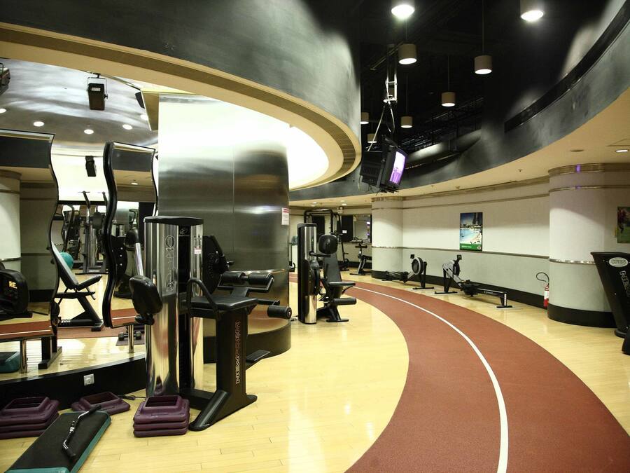 A gym with cardio machines, weightlifting equipment, and a running track.