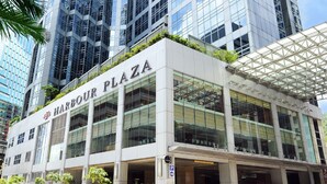 Un edificio moderno con el nombre 'Harbour Plaza' bien visible.