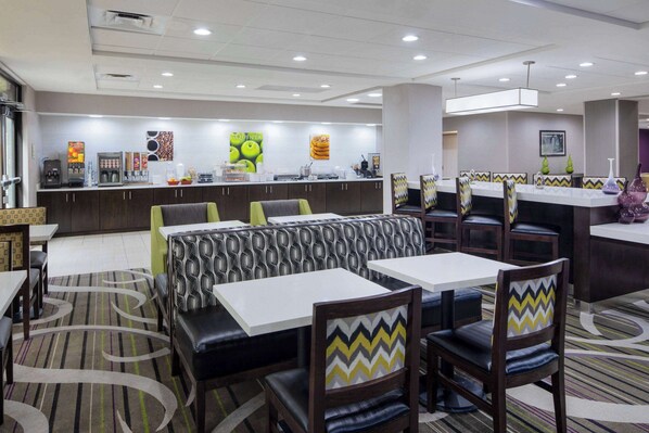 Un restaurante moderno con asientos tipo cabina, una barra con menú y una máquina de café.