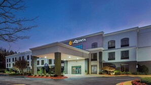 A hotel with a modern facade, a prominent entrance, and a well-maintained outdoor area with landscaping.