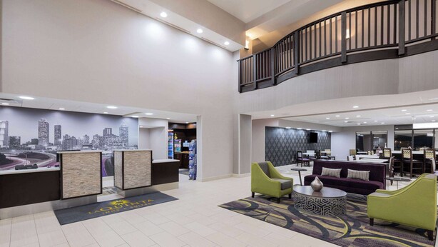 A spacious lobby with a reception desk, seating area, and a cityscape mural.