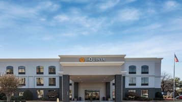 Un hôtel La Quinta doté d’une façade symétrique, de grandes fenêtres et d’une entrée centrale.