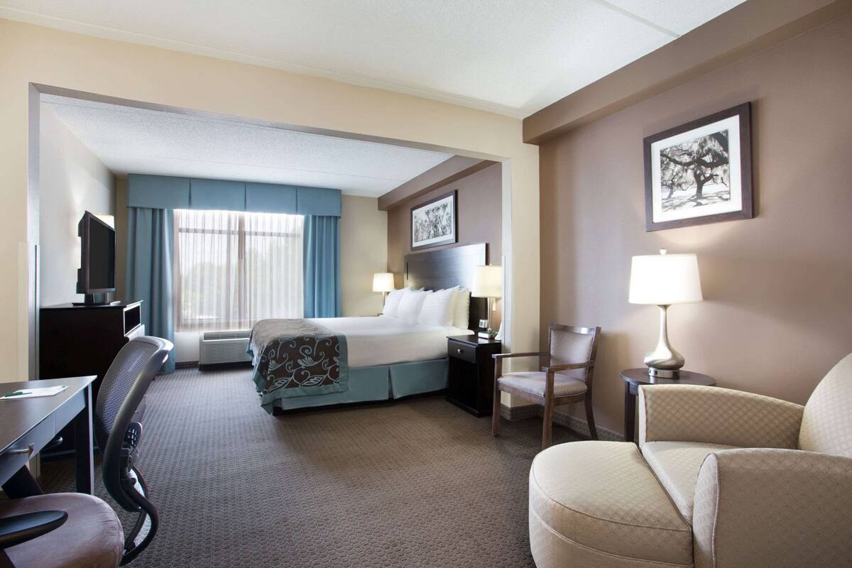 Une chambre d’hôtel équipée d’un lit, d’un bureau, d’une chaise et d’un téléviseur.