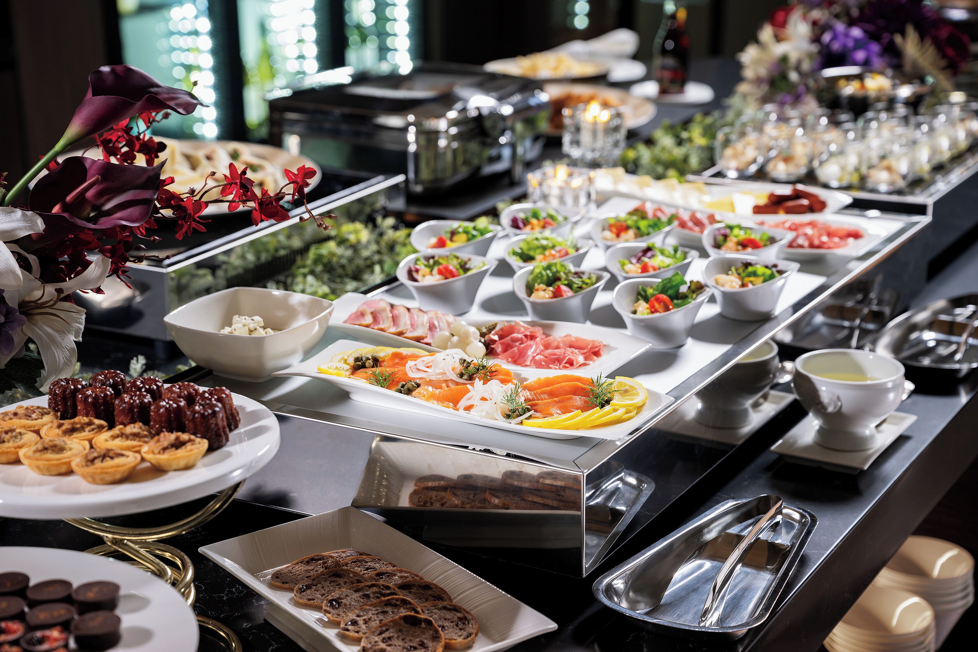 A buffet with various food items including salads, meats, and pastries.