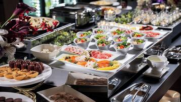 A buffet with various food items including salads, meats, and pastries.