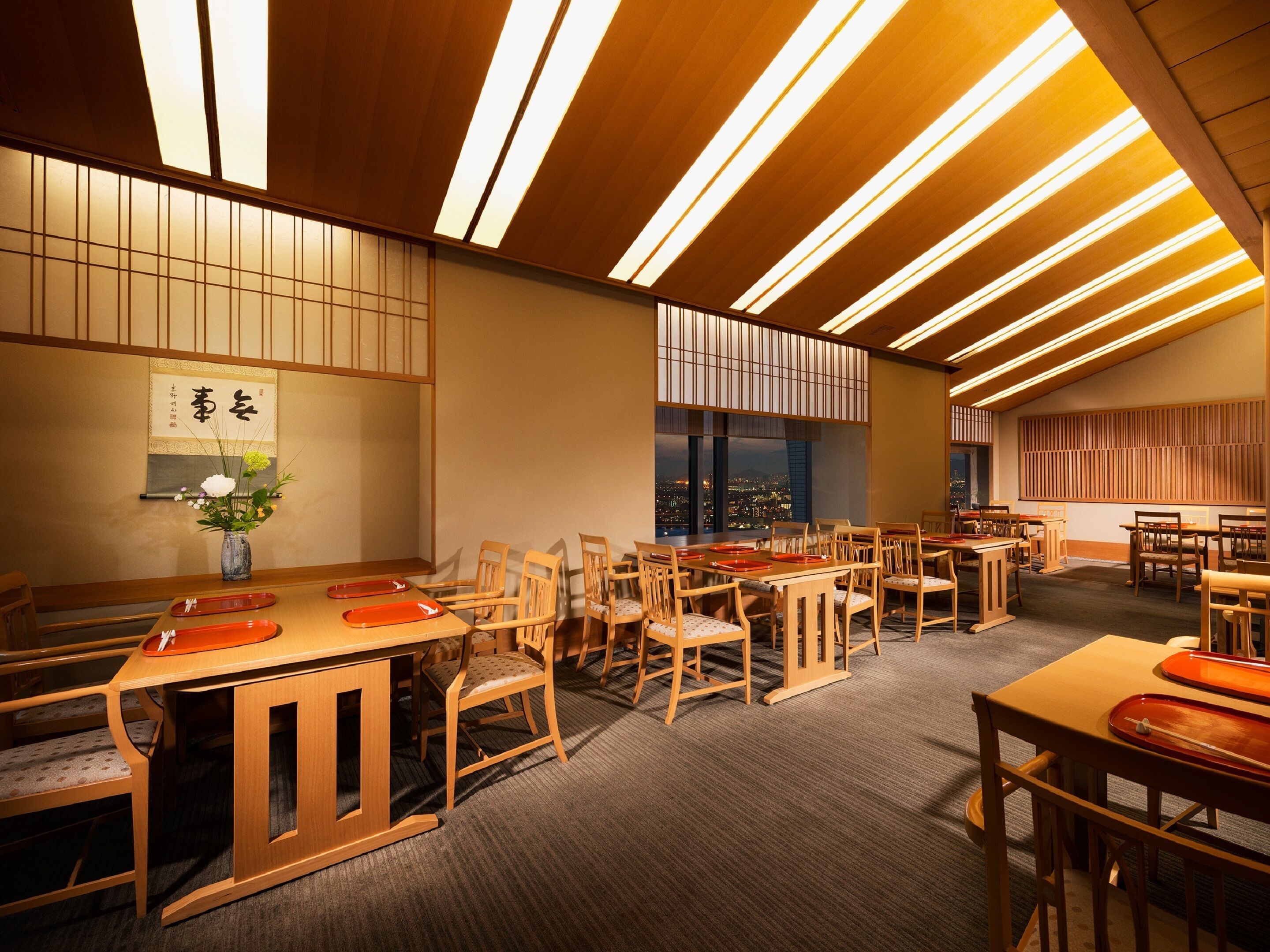 A spacious dining area with wooden furniture and a view of the cityscape.