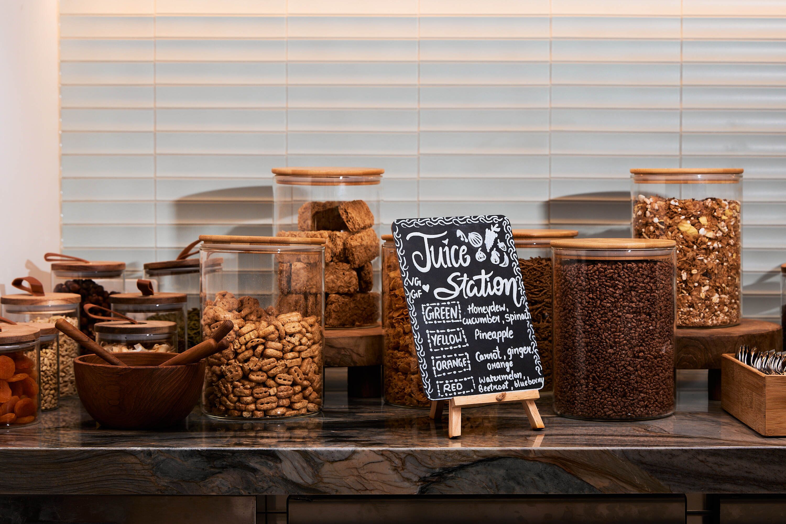 Exposição de diversos alimentos em potes e tigelas, com um quadro negro exibindo diferentes sabores.