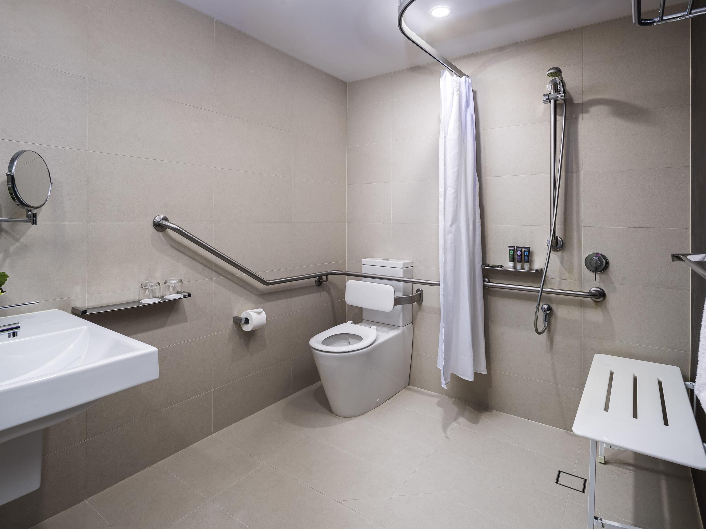 A modern bathroom with a toilet, shower, and sink.