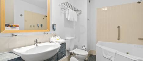 Un baño moderno con un lavabo grande, inodoro y bañera.