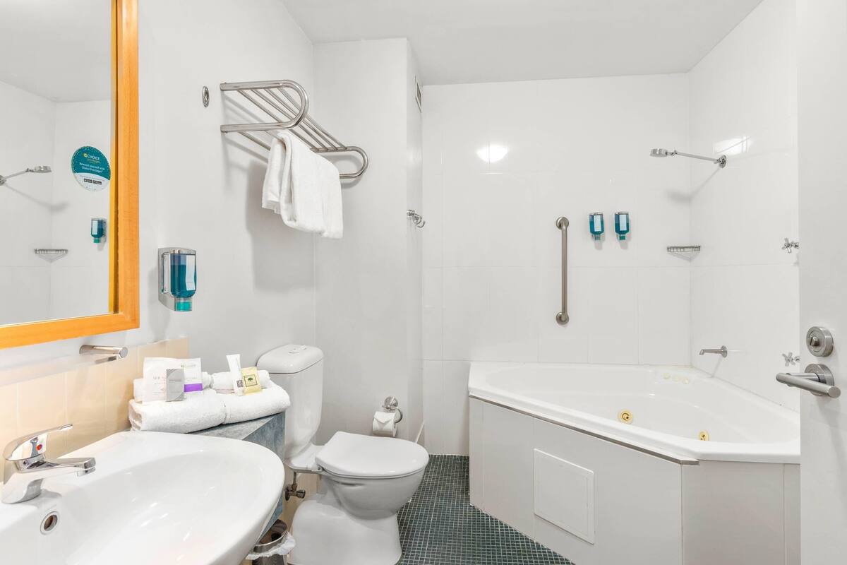 Un baño con lavamanos, inodoro y bañera.