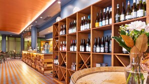 A bar area with shelves of wine bottles, a round bar counter, and a tiled floor. - Quality Hotel Dickson (Dickson)