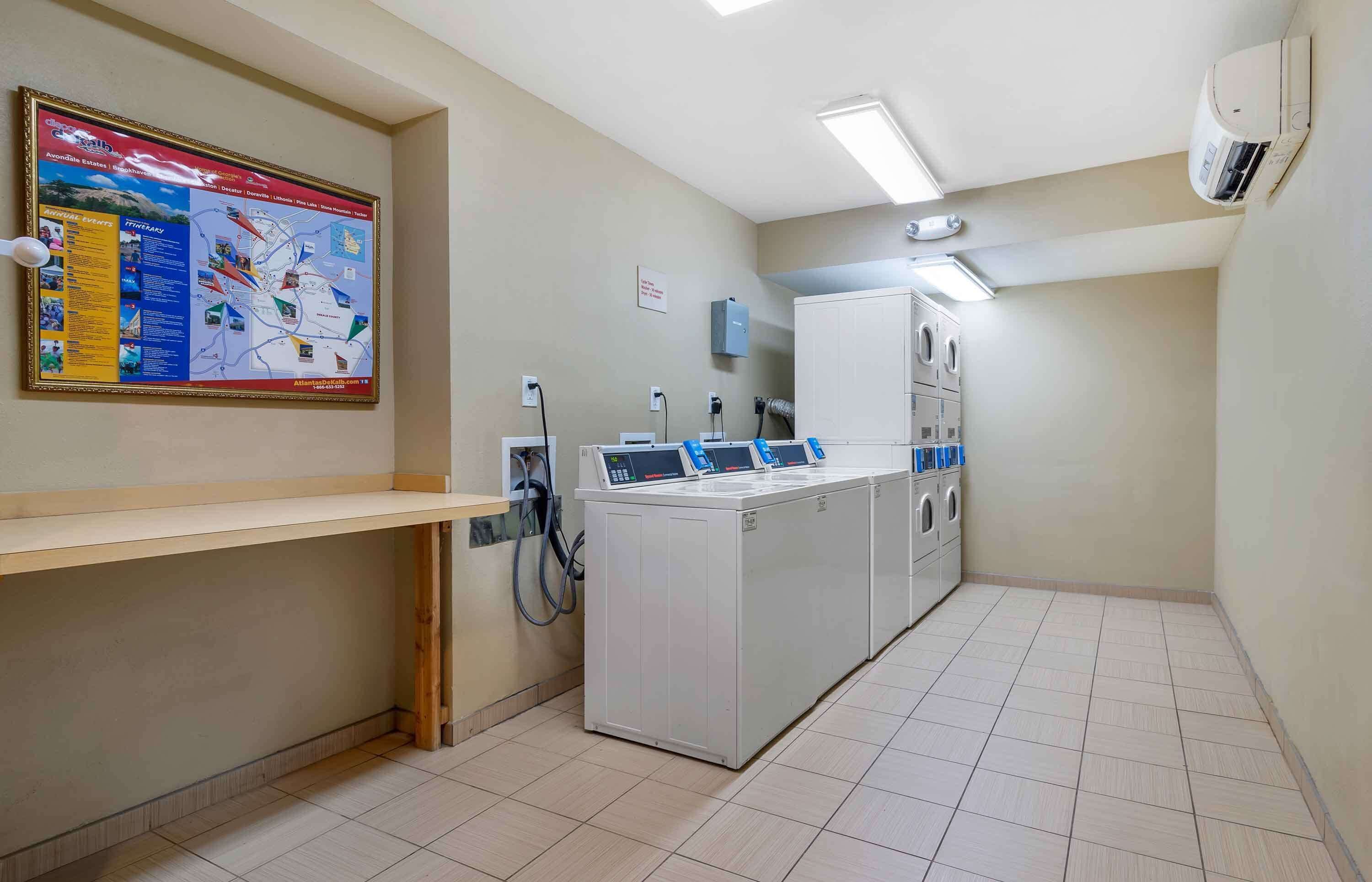 A laundry room with a large map on the wall, a washing machine, and a dryer.