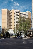 Un hotel alto de varios pisos, con fachada curva y un letrero llamativo.