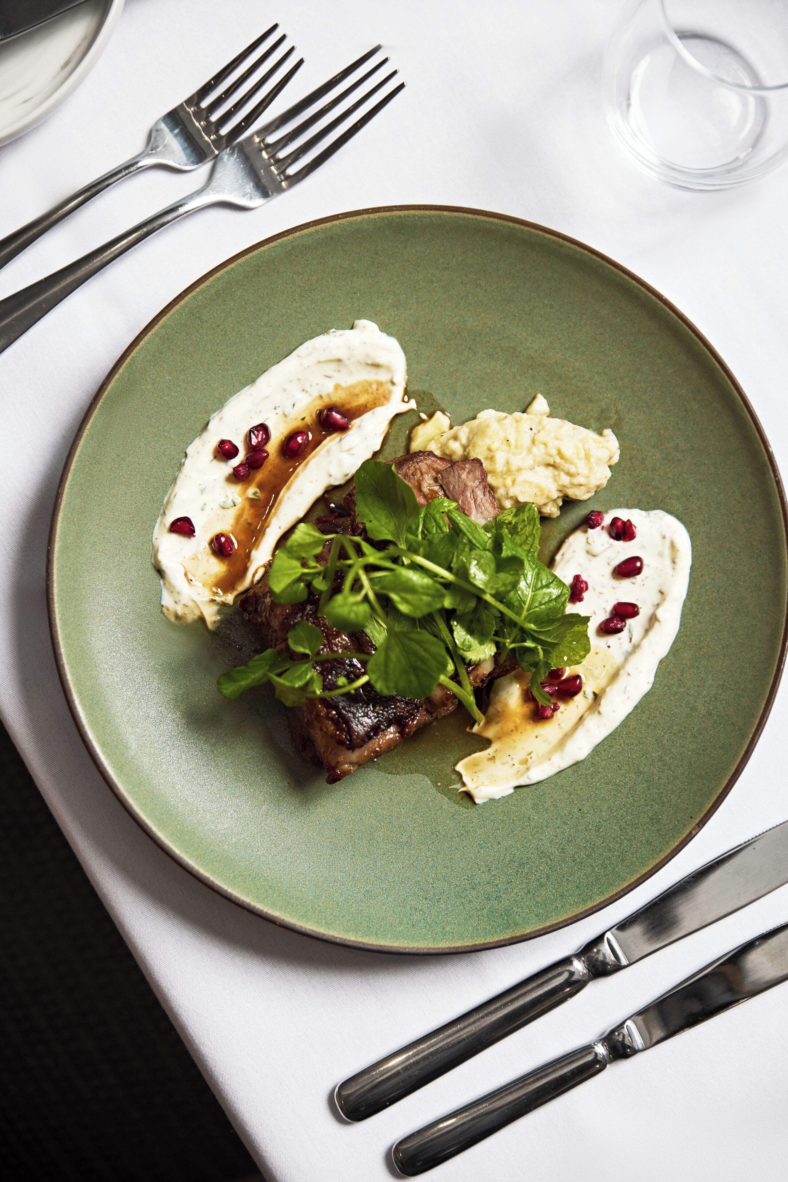 A plate with food, a fork, and a knife on a table.