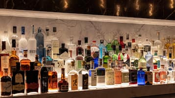 A bar with a variety of liquor bottles displayed on a marble countertop.