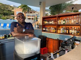 Zona de bar con una amplia selección de licores, barra y vistas a la piscina.