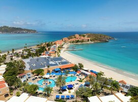 Un resort con zona de piscina, acceso a la playa y vistas al océano.