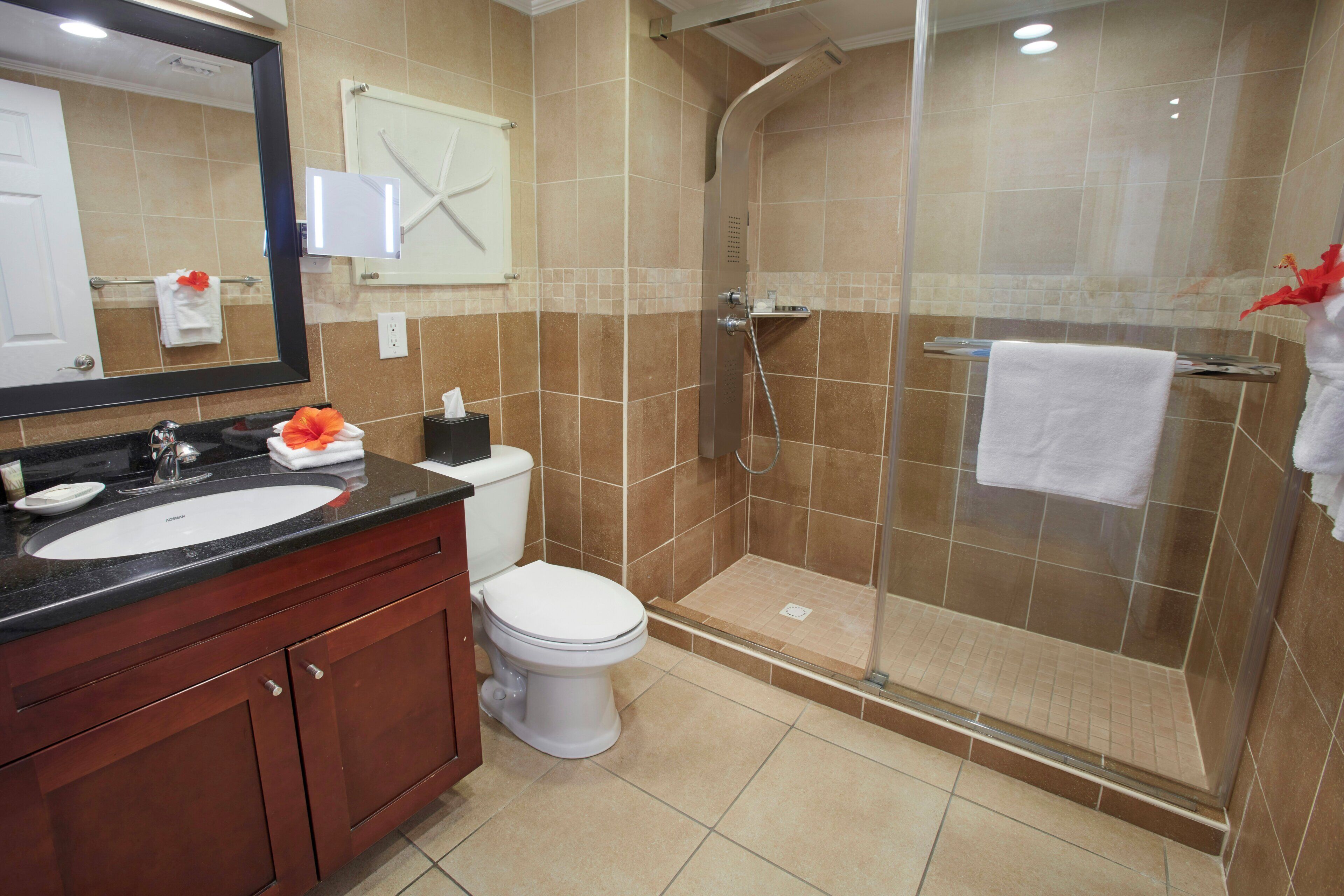 A bathroom with a sink, toilet, and shower.