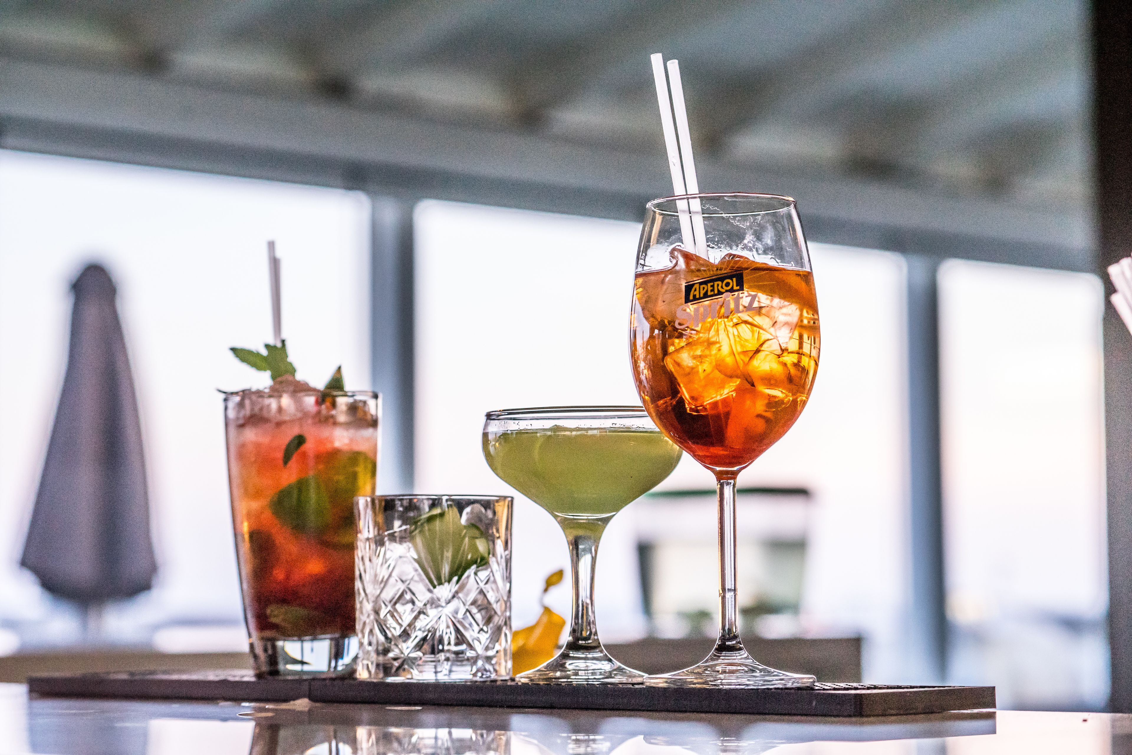 Tres vasos de bebidas diferentes sobre una bandeja.