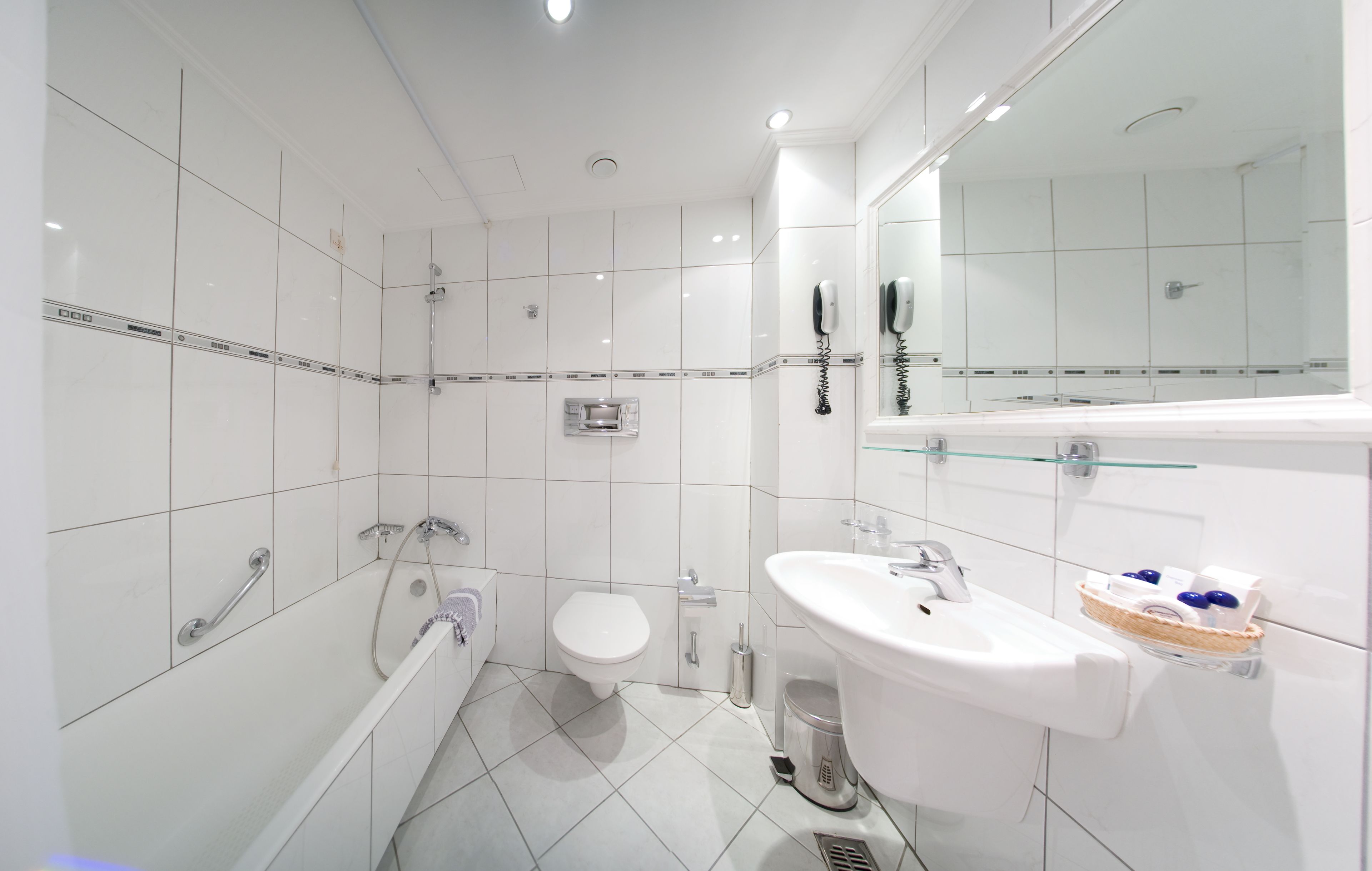 Een moderne badkamer met een badkuip, toilet en wastafel.