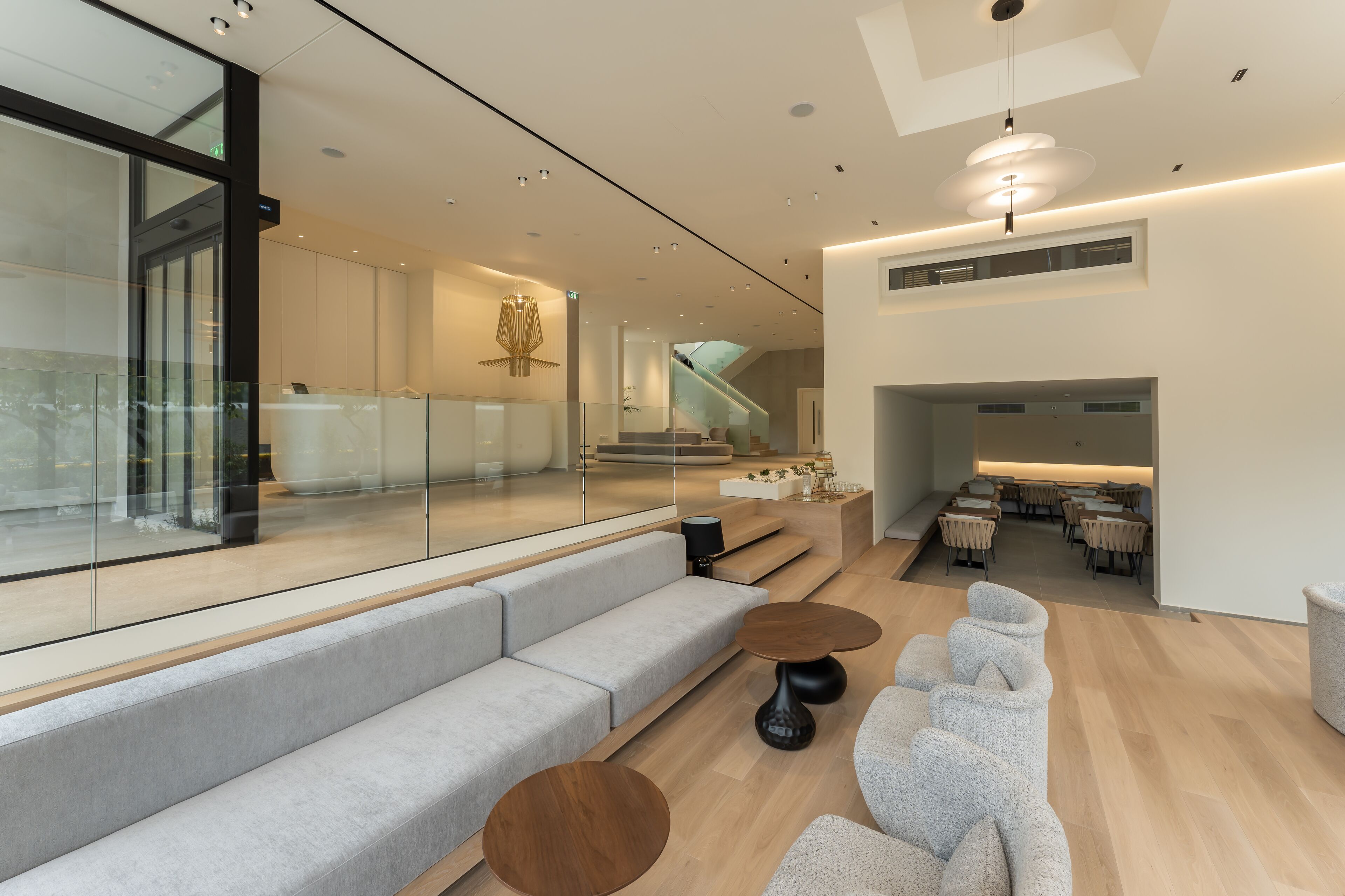 A modern interior with a glass wall, a staircase, and a dining area.