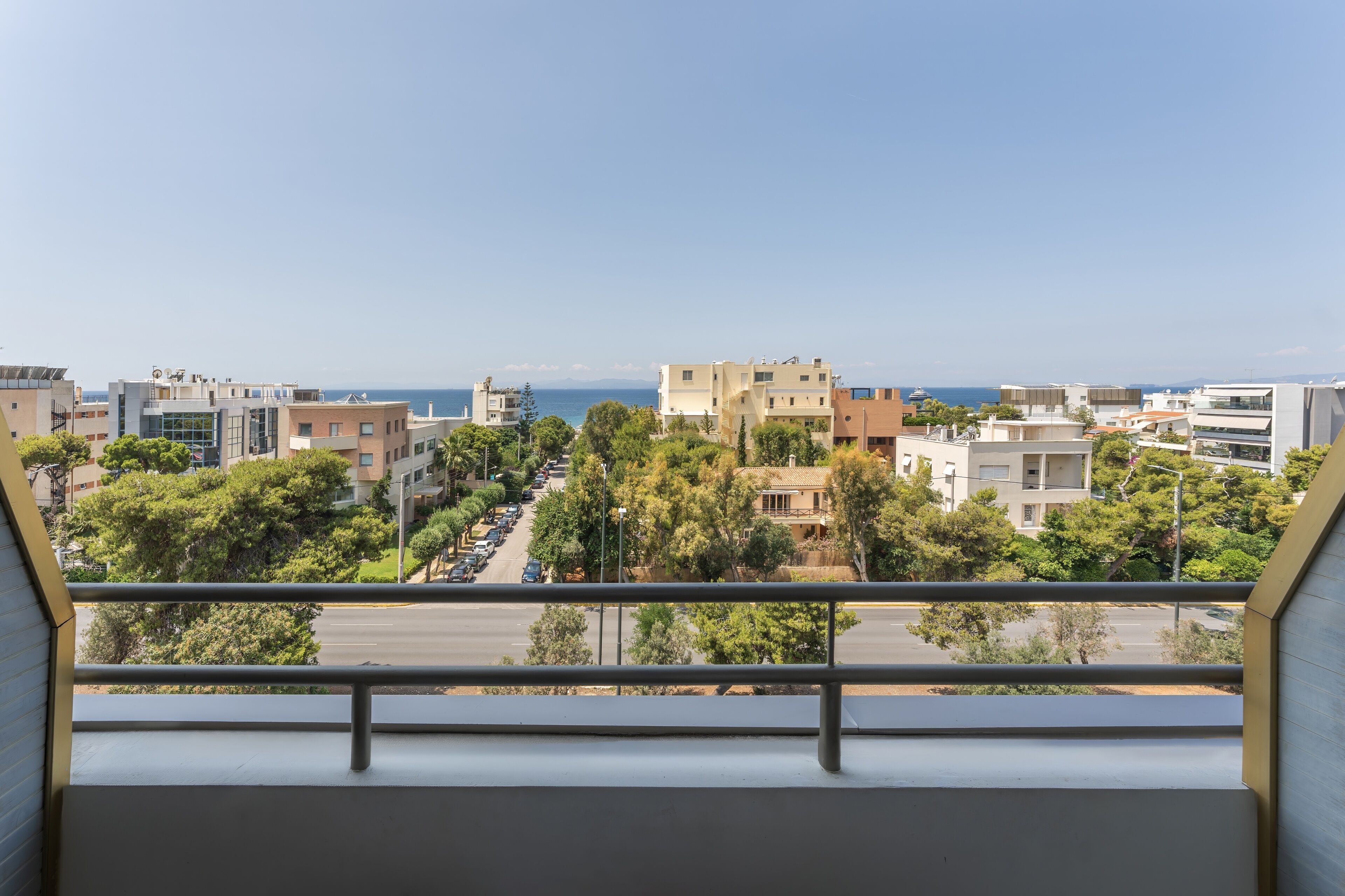 A balcony with a view of a cityscape and the sea.