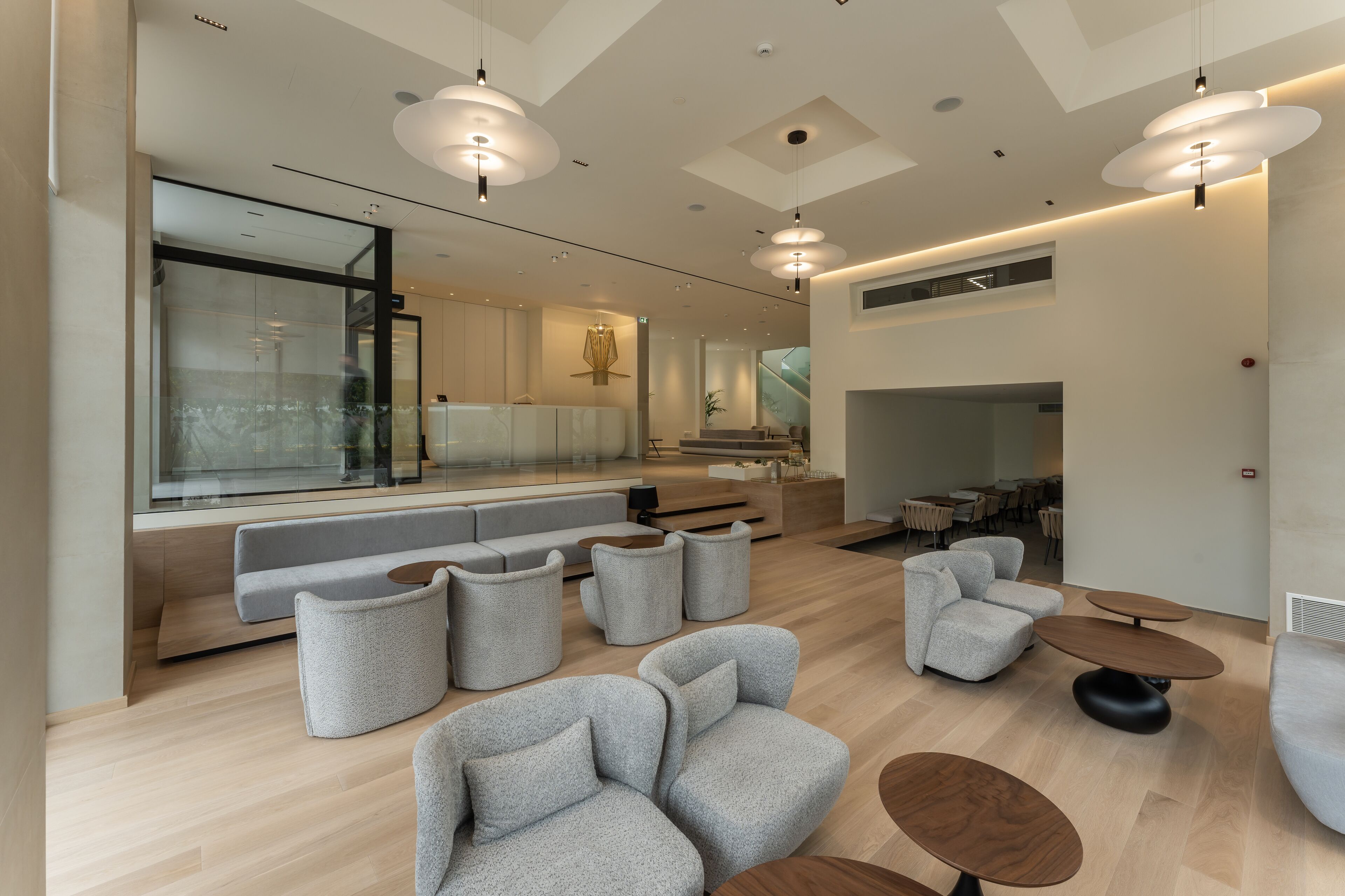A modern interior with a seating area, wooden flooring, and pendant lighting.