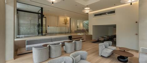 A modern interior with a seating area, wooden flooring, and pendant lighting.