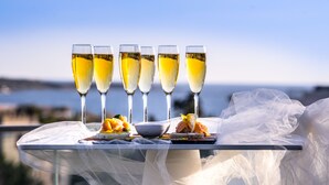 Una mesa con cinco copas de champán y un plato de postre cubierto con un mantel blanco.