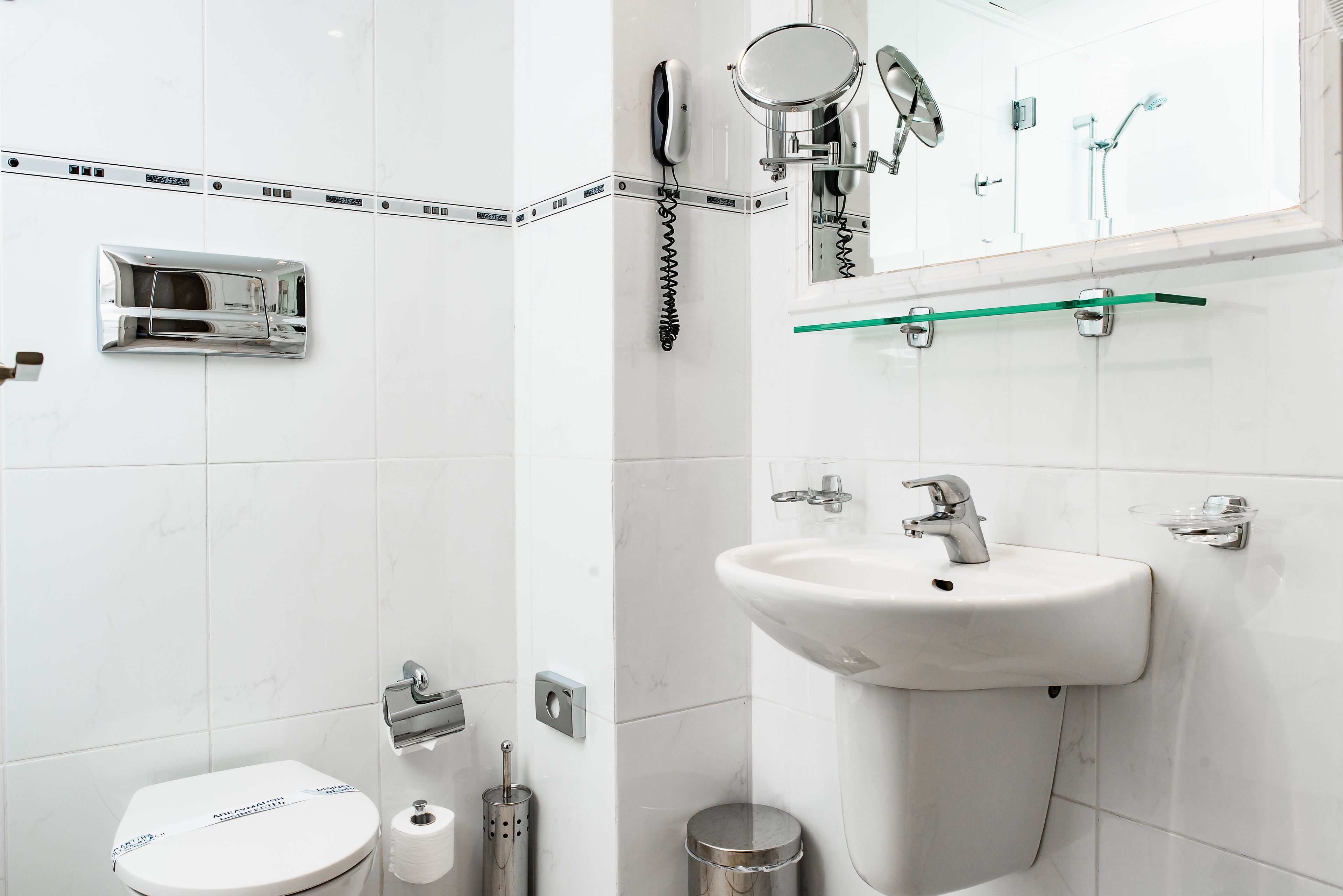 Une salle de bain moderne équipée de toilettes, d’un lavabo et d’une douche.