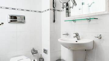 Une salle de bain moderne équipée de toilettes, d’un lavabo et d’une douche.