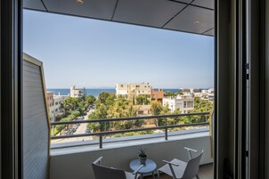 Un balcón con vista al mar y edificios.
